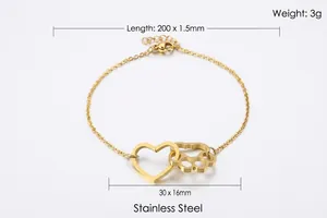 Detail of gold titanium steel bracelet showing heart and paw charms with lobster clasp