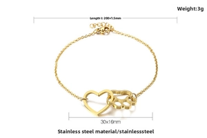 Detail of gold titanium steel bracelet showing heart and paw charms with lobster clasp