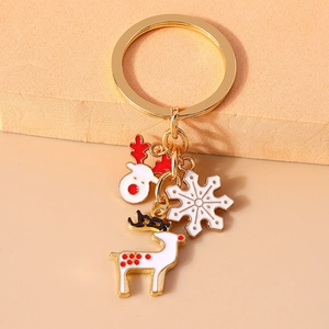 Christmas reindeer and snowflake enamel keychain with gold plating on a warm display