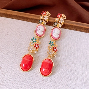 Détails de boucles d'oreilles rétro avec portraits en relief, émail et gemmes