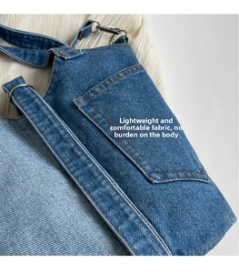 Detailed close-up of blue denim bucket bag texture with brown stitching and metal hardware
