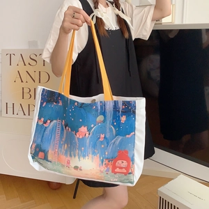 Détail du sac cabas en toile avec imprimé dessin animé et poignées jaune vif élégantes