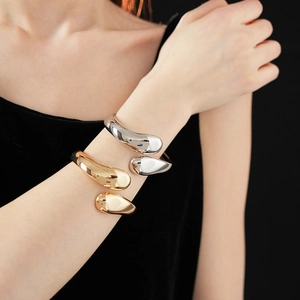 Nahaufnahme von gold- und silberfarbenen Teardrop-Armreifen in modernem Design