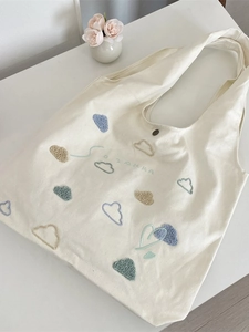 Canvas tote bag with cloud embroidery and SOZAKKA logo on a clean white desk