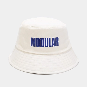 Dettaglio di un cappello da pescatore in tela bianca con scritta MODULAR blu e tesa trapuntata