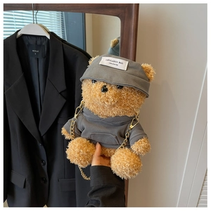 Detail der süßen braunen Plüsch-Teddybärtasche mit grauem Hoodie und goldener Kette