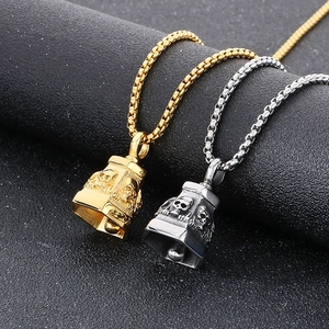 Macro detail of gothic skull bell pendants in polished gold and silver stainless steel
