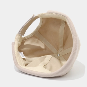 Inside view of a beige cotton brimless dock worker cap with adjustable strap and label