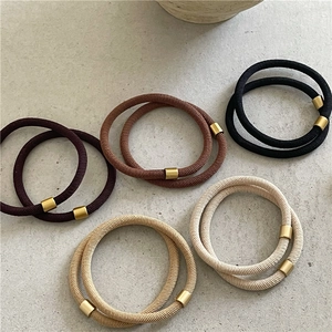 Detail of high-elasticity hair ties in coffee tones with elegant matte gold metal buckles