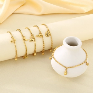18K gold plated anklet collection featuring cherry, moon, and shell charms on a display