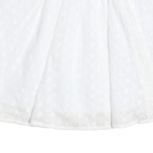 Detailed macro of white hollow floral embroidery on a low-cut dress hemline