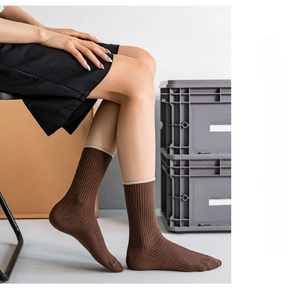 Detail view of brown ribbed mid-calf socks featuring a cute bear embroidery on the side