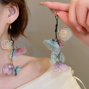 Detail of handmade fabric floral earrings with pastel mesh petals and gold hooks