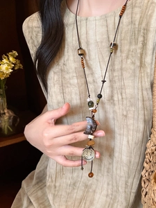 Detailansicht der Boho-Kette mit Holzperlen und einem Halbmond-Anhänger mit Smiley-Motiv