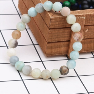 Close-up of 8mm tiger eye agate beaded bracelet on rustic wooden tray texture