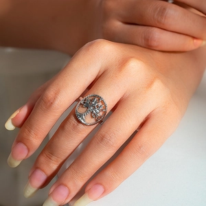 Detailed view of silver Tree of Life ring with hollow circular design on a model finger