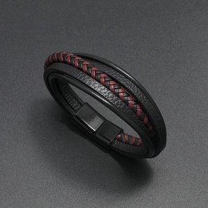 Detail of multi-layer black and red braided leather bracelet with black magnetic clasp