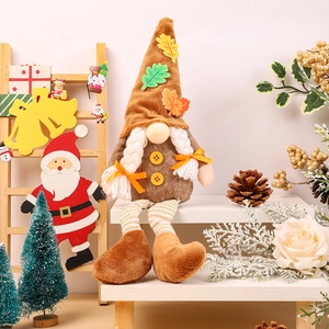 Close-up of harvest gnome plush with maple leaf hat and white braids for home decor
