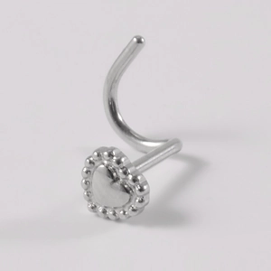 Detailed macro view of silver heart nose stud with beaded edge and curved steel post
