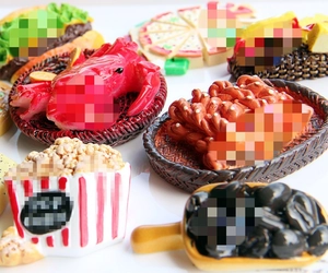 Macro shot of assorted resin food miniatures including lobster, popcorn, and pizza slices