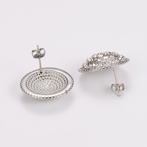 Detailed close-up of round silver stud earrings featuring sparkling pavé crystal stones