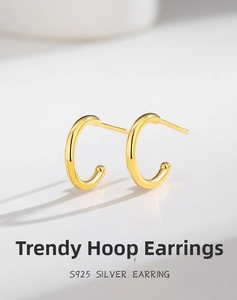 Macro view of gold S925 sterling silver C-shaped stud earrings with a polished mirror finish