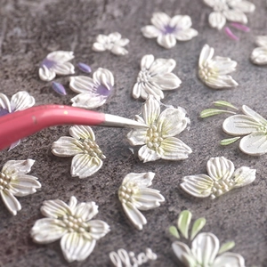 Detailed 5D embossed nail art stickers with white flower designs and raised 3D textures