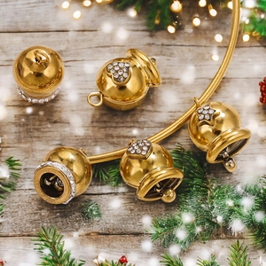Golden bell charm with white rhinestones and star patterns on festive wood decor
