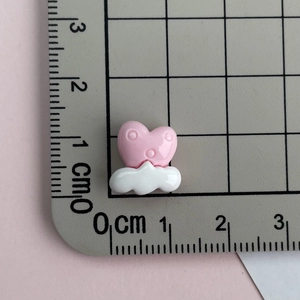 Pink heart on white cloud resin charm displayed next to a metric ruler for size reference