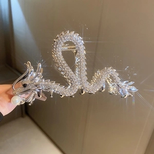 Detailed view of silver dragon hair claw clip with rhinestones and a white pearl accent