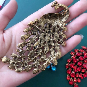 Vintage gold peacock brooch with crystal hollow feathers and intricate metal engraving