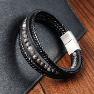 Detail of multi-layer black braided leather bracelet with stone beads and silver magnetic clasp
