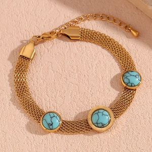Macro shot of 18K gold braided mesh bracelet with round turquoise and Roman numerals