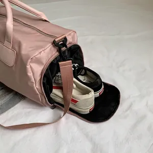 Pink nylon sports duffel bag featuring a large side shoe compartment and water-resistant fabric
