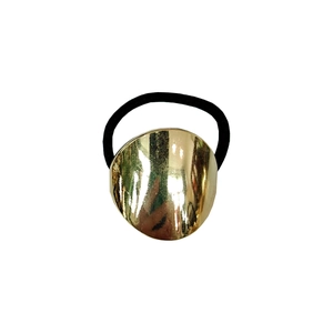 Macro detail of minimalist golden metallic oval buckle on high-elastic black hair tie