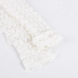 Close-up of white seersucker fabric featuring a distinctive 3D bubble pleated texture