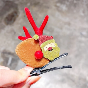 Detail of a Christmas reindeer antler clip with Santa icon and red flocking texture