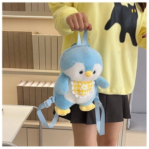 Detail of blue plush penguin backpack showing yellow plaid bib with flower embroidery