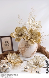 Detail of silver Christmas flowers with gold sequins in a vintage ceramic vase decoration