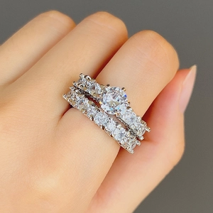 Detailed close-up of a silver-toned two-piece bridal ring set with sparkling round zircons