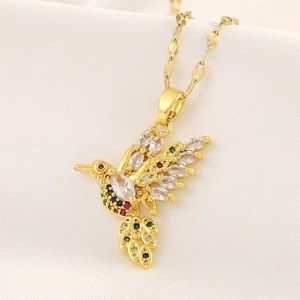 Detailed close-up of a hummingbird pendant featuring colorful zircons on silk background