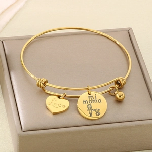 Detailed macro shot of golden MOM bracelet with Love heart and mi mama pendants