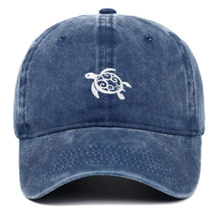 Vue détaillée de la broderie tortue sur casquette de baseball en denim délavé bleu foncé