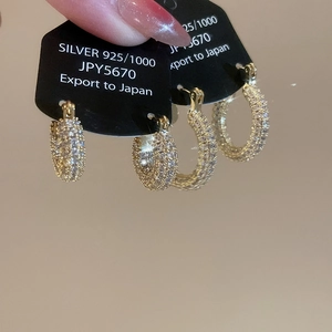 Close-up of gold-plated silver hoop earrings with sparkling cubic zirconia pavé setting