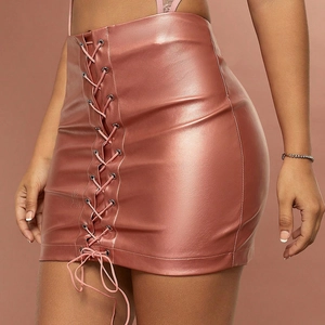 Detail of rose gold metallic PU leather mini skirt featuring side lace-up cross straps