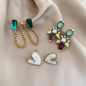 Detailed set of vintage earrings featuring emerald stones, colorful gems, and heart studs