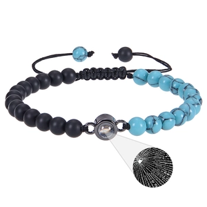 Makroaufnahme von Projektionsstein mit 100 Sprachen Ich liebe dich und Blauem Türkis-Armband