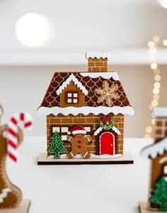 Close-up of felt gingerbread house decor with wooden base and festive bokeh lights