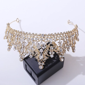 Detailed close-up of golden bridal crown with crystals on a black jewelry box