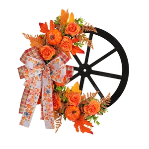 Autumn harvest wreath featuring black carriage wheel with orange roses and mini pumpkins